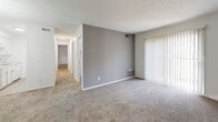 Located at 800 Valley Brook Dr in Milford, Ohio, this single-floor unit offers a straightforward, functional layout designed for comfortable everyday living. The floor plan, visible through the 3D model, reveals a series of well-proportioned rooms connected by a central hallway, providing clear separation between living and private spaces.

The main living area features neutral-toned carpeting and a textured ceiling, with a large sliding glass door fitted with vertical blinds that allows natural light to filter in. A gray accent wall adds a subtle visual contrast to the otherwise crisp white walls. The hallway extends toward the bedrooms, maintaining a consistent design aesthetic throughout.

The bedrooms are carpeted and finished with white walls and textured ceilings. Each room includes a window with horizontal blinds offering views of the surrounding greenery, contributing a sense of openness to each space.

Two bathrooms serve the unit. One features wood-look vinyl flooring, a white vanity, and a tub-shower combination with white tile surround. The second bathroom similarly features wood-look flooring, a white vanity, toilet, and an over-toilet storage cabinet with brass hardware. Both bathrooms maintain a clean, cohesive white palette throughout.