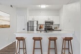 This contemporary 850 sq ft apartment in Richardson, TX offers a harmonious blend of style and functionality. The open-concept living area showcases sleek wood-look flooring, creating a seamless flow between the kitchen and living spaces. The kitchen boasts white cabinetry, stainless steel appliances, and a convenient island, perfect for meal prep or casual dining.

The spacious primary bedroom, measuring 330 sq ft, features plush carpeting and a large window with blinds for privacy and light control. A ceiling fan adds comfort and air circulation. The apartment includes two bathrooms, both featuring modern fixtures and ample vanity space.

Storage is abundant with a walk-in closet equipped with wire shelving. The unit also includes a private balcony or patio, accessible through sliding glass doors, offering an outdoor extension to the living space.

Throughout the apartment, recessed lighting and modern light fixtures provide a bright, welcoming atmosphere. The neutral color palette allows for easy personalization. With its thoughtful design and updated amenities, this apartment offers a comfortable and stylish living environment in a desirable Richardson location.