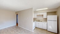 Located at 5000 Denton Hwy in Haltom City, TX, this one-bedroom, two-bathroom unit offers a practical and efficient single-floor layout. The living area greets you at the entrance with light wood-look vinyl flooring, neutral beige walls, a textured ceiling, and a wall-mounted HVAC unit. A window allows natural light to fill the space, contributing to a bright and open feel.

The kitchen flows directly off the living area and is equipped with white cabinetry, light stone-look countertops, a double-basin sink, a white electric range with coil burners, and an over-the-range microwave. Ample upper and lower cabinet storage makes the kitchen functional despite its compact footprint.

The bedroom is a comfortable size, featuring plush carpeting, a large window with vertical blinds, and a wall-mounted HVAC unit. A double sliding-door closet provides generous storage space. The neutral color palette throughout creates a calm and cohesive atmosphere.

The two bathrooms are clean and simply appointed. One features a tub-shower combination with white tile surround and chrome fixtures. The other includes a vanity with a white sink, a large mirror, and a towel bar. Both bathrooms maintain a crisp, clean aesthetic consistent with the rest of the unit.