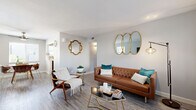 Located at 3030 N 7th St in Phoenix, AZ, this thoughtfully designed one-bedroom, one-bathroom residence offers a comfortable and stylish single-floor layout. The living room serves as a welcoming centerpiece, featuring wood-look flooring, large windows that invite natural light, and a bright, neutral color palette throughout. The space flows naturally into a dedicated dining area, which includes a ceiling fan, a window with outdoor views, and room for a full dining set. A hallway connects the main living spaces to the private quarters of the home. The galley-style kitchen is efficiently laid out with rich wood cabinetry, stainless steel appliances including a full-size refrigerator and dishwasher, and clean white countertops with a subway tile backsplash. The bedroom is a comfortable retreat featuring a ceiling fan, a large window, and direct access to a dedicated closet with built-in shelving and hanging space. The full bathroom includes a tub-shower combination, a pedestal sink, and a small window for ventilation. Wood-look flooring runs consistently throughout the entire unit, tying the spaces together cohesively. A private patio rounds out the offering, providing an outdoor space ideal for the warm Phoenix climate.