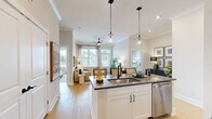 Located at 1020 Port Royal Trail in Myrtle Beach, SC, this thoughtfully designed 2-bedroom, 2-bathroom single-floor residence offers a bright and cohesive living experience. The open-concept layout seamlessly connects the kitchen, dining, and living areas, creating an inviting central space filled with natural light from large windows. The kitchen is a standout feature, boasting white shaker cabinetry, dark countertops, stainless steel appliances, and a central island with pendant lighting and bar seating — ideal for both cooking and casual entertaining. The living room is warm and welcoming, with a ceiling fan, large windows framing outdoor views, and access to a private patio. The generously sized primary bedroom features light wood flooring, ample closet space, and an en-suite bathroom with a glass-enclosed shower. The second bedroom is equally well-appointed with natural light and dedicated closet storage. A second full bathroom includes a soaking tub and shower combination with crisp tile finishes. Throughout the home, light wood-style flooring, neutral tones, and clean architectural lines create a cohesive, modern aesthetic. Additional conveniences include a pantry, in-unit laundry room, and multiple closets for generous storage.