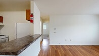 Located at 2355 White Birch Ln in Joliet, IL, this 2-bedroom, 1-bathroom residence offers a practical and comfortable single-floor layout. The galley-style kitchen is well-appointed with warm oak cabinetry, dark granite-look countertops, a gas range, refrigerator, and dishwasher, all set above durable wood-look flooring that extends into the living area. The combined kitchen and living room provides an open, functional space with neutral white walls and natural light from a large window, complemented by a wall-mounted air conditioning unit and baseboard heating. Both bedrooms are carpeted and feature natural light from windows with blinds, baseboard heating, and generous closet space — the primary bedroom notably includes a double set of sliding closets. The full bathroom is clean and bright, featuring a white tub and shower surround, wood-look flooring, and a linen closet. Throughout the residence, the consistent use of neutral tones and warm wood-look finishes creates a cohesive, welcoming ambiance. This well-organized layout maximizes the use of every square foot, making it a practical home in a residential Joliet neighborhood.