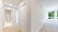 Located at 3488 Ketcheson Rd in Richmond, British Columbia, this well-designed 2-bedroom, 2-bathroom unit offers a clean, modern aesthetic across a single floor. Light-toned hardwood flooring runs throughout the living areas and bedrooms, contributing to a bright and cohesive feel.

The open kitchen and living area serves as the heart of the unit. The kitchen is outfitted with two-tone cabinetry — natural wood lower cabinets paired with crisp white upper cabinets — complemented by a light countertop, tile backsplash, and a full suite of stainless steel appliances including a refrigerator, range, and over-the-range microwave.

Both bedrooms are finished with the same light hardwood flooring and neutral walls. Large sliding windows frame lush green tree views and provide access to an outdoor balcony area, filling each room with natural light. The primary bedroom offers a comfortable footprint well-suited for a full bedroom setup.

The two bathrooms feature elegant marble-look porcelain tile on both the floors and walls, paired with light wood vanity cabinetry and light countertops. One bathroom includes a soaking tub and tiled shower surround. A hallway connects the rooms efficiently, and a dedicated closet provides additional storage. The overall ambiance is clean, contemporary, and move-in ready.