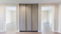 Located at 520 N Central Ave in Glendale, CA, this modern single-floor residence offers three bedrooms, two bathrooms, and a thoughtfully designed layout that maximizes comfort and functionality. The interior is finished with light-toned luxury vinyl plank flooring throughout, complemented by neutral warm-beige walls and clean white trim that create a bright, cohesive aesthetic.

The kitchen is a standout feature, showcasing flat-panel cabinetry in soft grey and natural wood tones, white quartz countertops, stainless steel appliances including a gas range and refrigerator, and a built-in microwave — all bathed in natural light. The adjacent living room benefits from large corner windows that invite ample sunlight and offer urban views of the surrounding Glendale cityscape.

The spacious primary bedroom connects directly to a private bathroom and is generously proportioned for a full furniture arrangement. The bathrooms feature large-format grey marble-style tile, a soaking tub with an overhead rain shower, and modern vanities. Secondary bedrooms are well-sized with windows providing natural light and city views.

Hallways are accented with sleek, full-height wood-grain panel closet doors, while a dedicated walk-in closet provides built-in shelving and double hanging rods for ample storage. The overall design reflects a clean, contemporary sensibility throughout.
