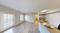 This thoughtfully designed 1-bedroom, 1-bathroom residence offers a functional and comfortable single-floor layout. The open-concept living and dining area is finished with light wood-look flooring and neutral gray tones, creating a bright and welcoming atmosphere. Natural light filters in through multiple windows with blinds, complementing the airy feel of the space. A sliding glass door leads to a private balcony, extending the living area outdoors.

The kitchen features a peninsula breakfast bar that opens to the living and dining area, white cabinetry, stainless steel appliances including a range, microwave, refrigerator, and dishwasher, along with built-in open shelving for added storage and display.

The bedroom is generously sized, finished with plush carpet flooring and equipped with a ceiling fan with light fixture. Three closets throughout the unit provide ample storage. The bathroom includes a full tub-shower combination, a vanity with white cabinetry, and wood-look flooring that ties into the rest of the home.

A dedicated in-unit laundry room accommodates a full-size washer and dryer with overhead shelving for additional storage, adding exceptional convenience to daily living.
