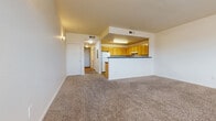 This single-floor residential unit offers a practical and comfortable layout designed for everyday living. The entry foyer greets you with light tile flooring that transitions into plush wall-to-wall carpeting throughout the main living areas and bedrooms, providing a warm and cohesive feel.

The open-concept living room is generously proportioned, featuring large windows that frame views of the surrounding cityscape and allow ample natural light to fill the space. The area flows seamlessly toward the kitchen, which is accessible via a pass-through counter bar — ideal for casual dining or entertaining.

The kitchen is well-appointed with an abundance of honey-toned wood cabinetry offering extensive storage, dark countertops, wood-look flooring, and a full suite of white appliances including a refrigerator, electric range, and dishwasher. A double sink completes the functional layout.

The bedrooms are each carpeted and feature clean, neutral walls that create a calm and versatile atmosphere. Several rooms include louvered closet doors, offering organized storage solutions. The unit's straightforward, efficient floor plan connects all rooms through a central hallway, ensuring easy navigation throughout the space.