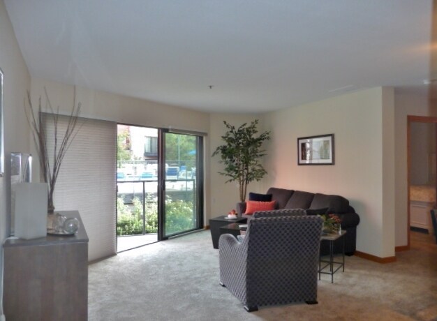 Light and airy living room overlooks the pool. - 1040 NW Naito Parkway