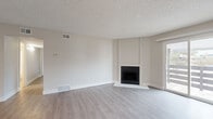 Located at 10225 E Girard Ave in Denver, Colorado, this single-floor residence offers a clean, contemporary aesthetic with thoughtful updates throughout. The spacious living area serves as the heart of the home, featuring light gray wood-look flooring, a textured ceiling, and a sleek fireplace framed by a crisp white surround — an inviting focal point for the room. A sliding glass door floods the space with natural light and provides direct access to a private balcony, extending the living area outdoors. The galley-style kitchen is efficiently designed with warm wood-toned cabinetry, white quartz countertops, and a full suite of stainless steel appliances, including a refrigerator, electric range, and over-the-range microwave. The bedroom is generously sized with a large window that brings in natural light and a full-width sliding closet offering ample storage. Two updated bathrooms feature wood-grain vanity cabinets, white quartz countertops, and framed mirrors. One bathroom includes a walk-in shower, while the other serves as a half bath. Consistent light-toned flooring and a neutral color palette flow throughout the entire space, creating a cohesive and modern atmosphere well-suited to Denver living.