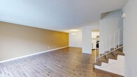 Located at 16946 Saddlewood Trail in Minnetonka, MN, this two-story, 2-bedroom, 2-bathroom home offers a well-organized layout spread across two floors. The main level features a spacious open-concept living and dining area with light wood-tone flooring, neutral warm-toned accent walls, and a textured ceiling. A chandelier adds a touch of elegance to the dining space, while large sliding glass doors and windows allow natural light to fill the room. The kitchen is equipped with white cabinetry, light quartz countertops with a breakfast bar peninsula, recessed lighting, and stainless steel appliances, including a range and refrigerator. Upstairs, the generously sized primary bedroom includes plush carpeting, direct access to a private bathroom, and an expansive walk-in closet outfitted with wire shelving for ample storage. The second bedroom is carpeted and features a window with outdoor views. Both bathrooms are finished with quartz vanity countertops and large mirrors. A dedicated laundry room houses a full-size Whirlpool washer and dryer. With five closets throughout, this home provides exceptional storage. The layout is practical and functional, making it a comfortable and well-appointed residence in a suburban Minnetonka setting.