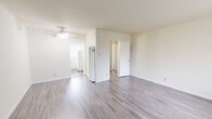 Located at 80 Forest Grove Dr in Daly City, CA, this single-floor unit offers a thoughtfully arranged layout that maximizes its cozy footprint. The living room is bright and open, featuring light gray wood-style laminate flooring and a ceiling fan, with a large window fitted with vertical blinds that allows natural light to fill the space and provides views of the surrounding neighborhood. A hallway connects the main living area to the rest of the unit, maintaining a clean and efficient flow throughout.

The kitchen is well-appointed with white shaker-style cabinetry extending from countertop to ceiling, offering ample storage. Granite-look countertops and a single-basin sink complement the white gas range, creating a functional and tidy cooking space. The same wood-style flooring continues seamlessly from the living areas into the kitchen.

The unit includes two bathrooms, one of which features a walk-in shower enclosed by frosted glass sliding doors with a chrome frame, along with a window that brings in natural light. The warm, neutral color palette used throughout the unit — from the cream-toned walls to the light flooring — lends a clean, airy ambiance. A wall-mounted heating unit provides climate control, rounding out this practical and efficiently designed Daly City residence.