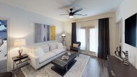 This single-floor residence showcases a thoughtfully designed open-concept layout that seamlessly connects the living, dining, and kitchen areas. Rich wood-look flooring flows throughout the main living spaces, complemented by crisp white walls and modern finishes. The living room features a ceiling fan, French doors that invite natural light, and ample space for comfortable furnishings.

The kitchen is well-appointed with light gray flat-front cabinetry, granite countertops, a white subway tile backsplash, and a full suite of stainless steel appliances including a French door refrigerator, electric range, built-in microwave, and dishwasher. A central island provides additional prep space and casual seating. Track lighting illuminates the kitchen efficiently.

Multiple bedrooms offer wood-look flooring, ceiling fans, and generous windows for natural light. The primary suite connects directly to a spacious walk-in closet with wire shelving systems and an ensuite bathroom featuring a double vanity with granite countertops and tile flooring. An additional bathroom includes a private water closet. Throughout the residence, a neutral palette and contemporary fixtures create a cohesive, modern ambiance.