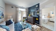This single-floor residence offers a thoughtfully designed layout that balances modern finishes with comfortable living. The kitchen is a standout feature, showcasing rich dark-wood cabinetry that extends to the ceiling for ample storage, granite countertops, a white subway tile backsplash, and a full suite of stainless steel appliances including a refrigerator, range, microwave, and dishwasher. A granite-topped island with bar seating provides additional prep space and a casual dining option. Warm hardwood-style flooring flows throughout the main living areas, connecting the kitchen to an inviting living room. The living space features a bold navy accent wall, a built-in shelving unit, and a set of glass French doors that open to a private patio, flooding the room with natural light and offering outdoor views. The bedroom is a calm retreat, carpeted for comfort, with a large window dressed in decorative curtains and blinds that allow for adjustable natural light. The bathroom is finished with granite countertops on dark cabinetry, a full-size soaking tub and shower combination with white tile surround, and a curved shower curtain rod for added space. Clean, neutral wall tones throughout lend the entire residence a cohesive and modern aesthetic.