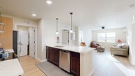 Located at 260 Spanish Moss Cir in Sebring, Florida, this single-story 2-bedroom, 2-bathroom home offers a thoughtfully designed open-concept layout that maximizes functionality and flow. Light wood flooring runs throughout, lending a clean, cohesive look to the entire space.

The kitchen serves as the heart of the home, featuring a central island with a white countertop, pendant lighting, a stainless steel dishwasher, stainless steel range, built-in microwave, and a mix of dark lower and light upper cabinetry. The island opens seamlessly into the combined dining and living area, which is bright and airy thanks to natural light from a large window. The living room includes a ceiling fan and a wall-mounted split air conditioning unit.

The generously sized primary bedroom is bright and comfortable, featuring a ceiling fan, a large window with natural light, and access to a walk-in closet with wire shelving. A second walk-in closet provides additional storage. The bathrooms are clean and practical, with dark wood vanities, white countertops, and large mirrors.

A dedicated laundry room houses a stacked washer/dryer unit alongside a water heater. The home's efficient layout and ample closet space — three closets total — make it a practical and comfortable residence in the heart of Sebring.