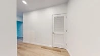 Located at 55 Riverside Dr in Yonkers, NY, this thoughtfully designed two-bedroom, two-bathroom residence offers a clean, modern aesthetic across a well-organized single-floor layout. Light oak-toned hardwood flooring runs throughout, complementing the crisp white walls and creating a bright, airy atmosphere.

The open-concept kitchen and living area serves as the heart of the home. The kitchen is a standout feature, showcasing white shaker cabinetry, a striking navy-blue island with a white quartz countertop, pendant lighting with warm brass accents, and a large window framing expansive water views — an exceptional detail that brings natural light and scenery into everyday living. A private balcony is accessible from the living area, extending the living space outdoors.

The primary bedroom is generously proportioned, with floor-to-ceiling windows offering views of the surrounding community, while the second bedroom is equally bright and well-sized. Three closets, including a walk-in with built-in shelving and hanging rods, provide ample storage.

Both bathrooms are finished with elegant marble-style porcelain tile flooring and walls. One bathroom features a walk-in shower with full tile surround and brushed nickel fixtures, while the other offers brass hardware accents. An in-unit laundry area adds further convenience to this well-appointed residence.