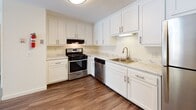 Located at 158 Concord Rd in Billerica, Massachusetts, this single-floor residence offers a well-organized layout with a clean, functional design throughout. The renovated kitchen is a standout feature, showcasing crisp white shaker-style cabinetry, marble-look countertops, and wood-look flooring. Stainless steel appliances — including a gas range, dishwasher, and refrigerator — are paired with a gold-finish sink faucet, lending a modern yet warm aesthetic. The kitchen opens to the main living area, creating a connected, practical flow. The living room is generously proportioned, featuring neutral carpet, a baseboard heating system, and a sliding glass door that leads to a private balcony with outdoor views. The bedroom areas are carpeted and filled with natural light through large multi-pane windows that overlook surrounding greenery. At least one bedroom includes a closet with built-in shelving. The bathroom is equipped with a full tub-shower combination, satin nickel fixtures, and a grab bar for added accessibility, with wood-look flooring that complements the rest of the unit. Throughout, the space features light neutral walls and clean finishes, creating a bright and move-in ready atmosphere.