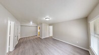 Located on Olson Lane in Pasadena, TX, this single-story home offers a functional and straightforward layout with three bedrooms, two full bathrooms, a living room, and a dedicated laundry area. The living room features wood-look laminate flooring, a front-facing window with blinds that bring in natural light, and a textured ceiling with flush-mount lighting. The space connects seamlessly to the kitchen, which is equipped with a coil-top electric range, a full-size refrigerator, and warm-toned oak cabinetry above. Each of the three bedrooms is finished with neutral carpet and ceiling fans with integrated lighting. The primary bedroom includes a built-in electrical panel access panel on the wall. Additional bedrooms feature windows with blinds, providing natural light and ventilation. Both bathrooms include a tub-shower combo with white tile surrounds, a toilet, and ventilation. Neutral, light-toned walls throughout the home create a clean and consistent aesthetic. The overall layout, as seen in the dollhouse view, is compact yet efficiently arranged, making practical use of the available floor space across all rooms.