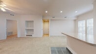 Located at 4320 W 6th St in Lawrence, Kansas, this two-bedroom, one-bathroom single-floor home offers a well-designed layout across a comfortable footprint. The open-concept kitchen and living area form the heart of the home, with the kitchen featuring white cabinetry with crown molding, a center island with countertop seating, tile flooring, recessed lighting, and white appliances including a refrigerator, range, microwave, and dishwasher. The kitchen flows seamlessly into the living room, which is carpeted and accented by built-in shelving and recessed lighting, offering a versatile space for both relaxing and entertaining. Both bedrooms are carpeted and include ceiling fans, crown molding, and windows with blinds that allow for natural light. The spacious primary bedroom provides direct access to the hallway and is positioned near the full bathroom and in-unit laundry area. The bathroom is well-appointed with white cabinetry, ample counter space, tile flooring, and an overhead cabinet for additional storage. A dedicated laundry area houses a full-size side-by-side washer and dryer. Two closets and a hallway complete the practical layout of this thoughtfully designed home.