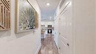 Located at 7450 SR-21 N in Port Wentworth, Georgia, this thoughtfully designed single-floor home offers three bedrooms and two bathrooms across a well-utilized layout. Wood-look flooring flows throughout the main living areas, complemented by crisp white walls and recessed lighting that create a clean, contemporary atmosphere.

The open-concept kitchen is a standout feature, boasting white shaker cabinetry, granite countertops, stainless steel appliances — including a dishwasher, microwave, range, and refrigerator — and a large center island with bar seating and stylish pendant lighting overhead.

The living room is bright and welcoming, featuring multiple windows dressed with floor-length curtains, a ceiling fan, and direct access to an outdoor area through a glass door. The primary bedroom offers a comfortable, carpeted retreat with a ceiling fan, while the spacious walk-in closet includes built-in wire shelving for ample storage.

The primary bathroom is well-appointed with granite-topped dual vanity, dark cabinetry, a glass-enclosed walk-in shower, and warm wood-look flooring. The second bathroom features a full soaking tub with shower combination. A connecting hallway with carpeted flooring links the bedrooms, providing a quiet and organized flow throughout the home.