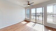 This 440 square foot apartment in New London, Wisconsin, offers a thoughtful layout maximizing its compact space. The open-concept kitchen and living area form the heart of the home, featuring light wood cabinetry, stainless steel appliances, and a subway tile backsplash. The kitchen is well-equipped with a full-size refrigerator, range, and dishwasher.

Throughout the apartment, warm wood flooring adds a touch of elegance and continuity. Large windows and a sliding glass door leading to a private balcony flood the space with natural light, creating an airy atmosphere. The balcony offers views of the surrounding cityscape, perfect for enjoying morning coffee or evening relaxation.

The bathroom is efficiently designed with a single vanity, toilet, and likely a shower (not visible in images). It maintains the apartment's modern aesthetic with light wood cabinetry and continues the wood flooring.

Recessed lighting throughout provides ample illumination, while a statement ceiling fan in the living area adds both style and function. The apartment's layout also includes a closet for storage, though its exact location is not specified in the images.

This apartment combines contemporary design with practical living, ideal for those seeking a low-maintenance, stylish urban dwelling in New London.