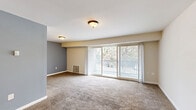 Located at 8529 Greenbelt Rd in Greenbelt, MD, this two-bedroom, one-bathroom unit offers a well-organized single-floor layout designed for comfortable everyday living. The expansive living room is a standout feature, highlighted by large sliding glass doors that flood the space with natural light and open onto a private balcony with outdoor views of surrounding greenery and flowering trees. Neutral-toned carpet and warm beige walls create a welcoming, cohesive atmosphere throughout.

The kitchen is thoughtfully appointed with warm wood cabinetry, dark granite-style countertops, a peninsula for additional prep space, tile flooring, and black appliances including a refrigerator, gas range, and dishwasher. A double sink adds functionality to the efficient layout.

The generously sized primary bedroom features carpeted flooring, a large window with natural views, and a dedicated closet. The second bedroom is similarly carpeted and bright, with its own window and closet access, complete with wire shelving for organized storage.

The bathroom is finished with large-format beige tiles, a mosaic accent border, a built-in shower niche, and a soaking tub, offering a clean and functional design. Overall, this unit provides a practical and comfortable living environment in a convenient Greenbelt location.