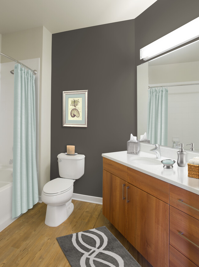 Upgraded bath with walnut cabinetry, white quartz countertop and hard surface flooring - Avalon Mosaic