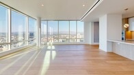 Located at 1000 W 8th St in the heart of Downtown Los Angeles, this elegantly appointed 3-bedroom, 6-bathroom residence delivers a refined urban living experience. Warm wide-plank hardwood flooring flows throughout the space, complemented by crisp white walls and recessed lighting that create a bright, modern aesthetic.

The open-concept living, dining, and kitchen area serves as the centerpiece of the home, with floor-to-ceiling windows framing striking panoramic views of the Los Angeles skyline and San Gabriel Mountains beyond. The gourmet kitchen features sleek stone countertops with subtle veining, a combination of high-gloss white and natural wood cabinetry, a gas cooktop, and pendant lighting that adds a refined finishing touch.

The generously sized primary bedroom is accompanied by a spa-caliber ensuite bathroom finished in floor-to-ceiling marble, complete with a glass-enclosed shower, freestanding soaking tub, and dual vanity with ambient under-cabinet lighting. A custom walk-in closet with built-in shelving, hanging rods, and integrated lighting provides exceptional storage. Additional bathrooms echo the same marble elegance seen throughout.

A dedicated laundry room with side-by-side Miele washer and dryer, stone countertops, and overhead cabinetry adds everyday convenience. With eight closets and thoughtfully connected hallways, this residence balances luxury with highly functional design.