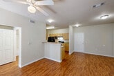 Located at 2000 Pine Crest Ave in Covington, Louisiana, this two-bedroom, two-bathroom single-floor residence offers a practical and comfortable layout. The open-concept living, dining, and kitchen area forms the heart of the home, bathed in natural light from multiple windows. Warm hardwood-style flooring runs throughout the main living spaces, complemented by ceiling fans that add to the airy feel.

The kitchen features light maple cabinetry, granite-style countertops, a breakfast bar peninsula, and black appliances including a range, microwave, refrigerator, and dishwasher. A pantry and dedicated laundry area add everyday convenience.

Both bedrooms are carpeted and equipped with ceiling fans, offering a cozy retreat. The spacious primary bedroom includes access to multiple closets and a private en-suite bathroom with a tub/shower combo, tile surround, and wood-style flooring. The second bathroom also features a tub/shower combo with clean white tile and matching cabinetry.

With five closets total, a hallway connecting the main spaces, and a private patio for outdoor enjoyment, this residence delivers efficient, well-organized living in a neutral, move-in-ready palette throughout.