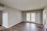 Located at 1606 Pinecroft Rd in Greensboro, NC, this single-floor, three-bedroom, one-bathroom home offers a practical and well-organized layout. Throughout the residence, wood-look flooring and neutral gray-toned walls create a clean, cohesive aesthetic.

The living room is a bright, open space anchored by French doors that flood the area with natural light and provide views of the surrounding greenery. Adjacent to the living area is a compact kitchen featuring a pass-through counter with a sink, seamlessly connecting to the main living space.

The primary bedroom is a comfortably sized room with a dedicated closet offering built-in storage. The additional bedrooms are well-proportioned, each benefiting from natural light through large windows that overlook the outdoors. One of the bedrooms features a skylight, adding an additional source of natural illumination.

The shared bathroom is efficiently designed, equipped with a combined tub and shower unit, a toilet, and overhead cabinetry for storage, finished with clean white fixtures and chrome hardware. A hallway connects the rooms, and two closets throughout the home provide ample storage. The overall design is straightforward and move-in ready, suited for comfortable everyday living.
