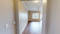 Located at 7300 Sir Walter Way in Knoxville, TN, this single-floor, one-bedroom, one-bathroom residence offers a thoughtfully designed layout that maximizes comfort and functionality. The entrance opens into a generous open-concept living area featuring rich hardwood-style flooring, warm neutral tones, and crown molding details that carry throughout the main living spaces. The kitchen is a standout, anchored by a large granite-topped island with pendant lighting overhead, dark espresso cabinetry, and stainless steel appliances including a refrigerator, range, and microwave. The adjoining dining area benefits from natural light through a window overlooking the outdoors, and is accented by a classic overhead light fixture. The living room continues the open feel, equipped with a ceiling fan and additional natural light. The spacious bedroom features plush carpeting, a ceiling fan, and a window with outdoor views. It connects directly to a well-sized walk-in closet outfitted with wire shelving on multiple walls for ample storage. The full bathroom includes a dark-cabineted vanity with a light countertop, a tiled tub-shower combination, and tile flooring. A dedicated laundry room with side-by-side washer and dryer and built-in shelving completes this well-appointed residence.