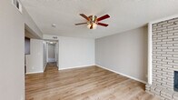 Located at 3634 Warwick Blvd in Kansas City, MO, this single-floor, two-bedroom, one-bathroom residence offers a thoughtfully laid-out interior with a neutral color palette and a mix of hard surface and carpeted flooring throughout. The living room serves as the centerpiece of the home, featuring a striking floor-to-ceiling whitewashed brick fireplace and large sliding glass doors fitted with vertical blinds that allow ample natural light to fill the space. A ceiling fan with a light fixture adds both comfort and functionality. Adjacent to the living area, the dining room is defined by warm luxury vinyl plank flooring and a pendant light overhead.

The galley-style kitchen is well-appointed with gray shaker cabinetry, granite countertops, a white subway tile backsplash, stainless steel appliances, and a stainless sink — providing an efficient and stylish workspace. The full bathroom includes a granite-topped vanity, wood-grain flooring, and a tiled tub-surround.

Both bedrooms feature plush carpet, ceiling fans, and closet storage. The spacious primary bedroom connects to a hallway and includes convenient access to an in-unit stacked washer and dryer. Textured ceilings are consistent throughout, adding classic character to the home.