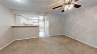 Located at 6228 S Dale Mabry Hwy in Tampa, Florida, this single-story unit offers a straightforward, functional layout designed for comfortable everyday living. The living area is generously sized, featuring neutral-toned carpet underfoot and a ceiling fan with a light fixture overhead. A textured ceiling runs throughout the space, adding subtle visual interest. The living area connects openly to the kitchen pass-through, creating a cohesive flow between the main living and cooking spaces.

The kitchen is efficiently arranged, featuring white cabinetry that extends to the upper walls for ample storage, light-toned countertops, a stainless steel sink, and white appliances including an electric range and refrigerator. Wood-look flooring in the kitchen provides a practical, easy-to-maintain surface that contrasts with the carpeted areas elsewhere in the unit.

The bedrooms are carpeted and well-proportioned, each equipped with a ceiling fan and windows fitted with blinds that allow natural light to filter in. One bedroom includes a closet with bifold doors, offering useful built-in storage. The neutral wall tones throughout the unit create a clean, versatile backdrop. Overall, the space presents a practical and livable environment in a convenient South Tampa location.