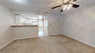 Located at 6228 S Dale Mabry Hwy in Tampa, Florida, this single-story unit offers a straightforward, functional layout designed for comfortable everyday living. The living area is generously sized, featuring neutral-toned carpet underfoot and a ceiling fan with a light fixture overhead. A textured ceiling runs throughout the space, adding subtle visual interest. The living area connects openly to the kitchen pass-through, creating a cohesive flow between the main living and cooking spaces.

The kitchen is efficiently arranged, featuring white cabinetry that extends to the upper walls for ample storage, light-toned countertops, a stainless steel sink, and white appliances including an electric range and refrigerator. Wood-look flooring in the kitchen provides a practical, easy-to-maintain surface that contrasts with the carpeted areas elsewhere in the unit.

The bedrooms are carpeted and well-proportioned, each equipped with a ceiling fan and windows fitted with blinds that allow natural light to filter in. One bedroom includes a closet with bifold doors, offering useful built-in storage. The neutral wall tones throughout the unit create a clean, versatile backdrop. Overall, the space presents a practical and livable environment in a convenient South Tampa location.