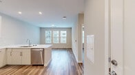 Located at 1900 S Hanover St in Baltimore's South Baltimore neighborhood, this well-appointed one-bedroom, one-bathroom unit offers a thoughtfully designed layout with modern finishes throughout. Warm wood-look plank flooring and neutral-toned walls create a clean, cohesive aesthetic across the entire space.

The open-concept kitchen is a standout feature, anchored by a large peninsula with a built-in sink, white quartz countertops, and abundant seating potential. White flat-front cabinetry reaches toward the ceiling, complemented by a classic white subway tile backsplash. Stainless steel appliances — including a refrigerator, range, microwave, and dishwasher — complete the chef-ready space.

The kitchen flows seamlessly into a bright living and dining area, where large windows allow generous natural light to fill the room. The bedroom is a comfortable retreat with its own large window overlooking the surroundings and direct access to a spacious walk-in closet outfitted with multi-tier wire shelving for versatile storage.

The full bathroom is finished with large-format tile flooring, a glass-enclosed walk-in shower with full tile surround, a wide single-sink vanity with quartz countertops, and a sizeable mirror with overhead lighting — delivering a clean, spa-like feel.