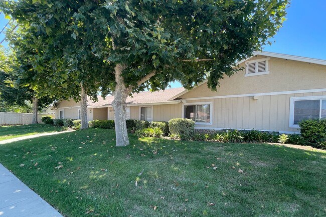 Paisajismo frontal con árboles de eucalipto maduros y césped bien establecido en Eucalyptus Apartments en Moreno Valley, California. - Eucalyptus Apartments