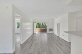 Located at 2611 W Baylor Cir in Anaheim, CA, this well-appointed 2-bedroom, 2-bathroom single-floor residence offers a bright and clean aesthetic throughout. Light wood-style flooring flows consistently across the living areas, connecting each space with a cohesive, modern feel.

The kitchen is equipped with white shaker-style cabinetry, marble-look stone countertops, a double stainless steel sink, and stainless steel appliances including a gas range and microwave. A peninsula counter opens toward the living area, creating a functional and social layout.

The living room features exposed beam detailing on the ceiling and a sliding glass door that opens to a balcony overlooking lush tropical greenery, filling the space with natural light and outdoor views.

The primary bedroom is generously sized and includes an exposed wood beam ceiling, a large window with garden views, and a closet. Both bathrooms are finished with white cabinetry, marble-style countertops, and light flooring. One bathroom includes a glass-enclosed walk-in shower with chrome fixtures and a wide vanity mirror with modern lighting.

The second bedroom is bright and open with ample wall space and a sliding mirrored closet. A hallway connects all rooms efficiently. The overall palette of whites and light neutrals gives the entire residence a clean, airy ambiance.