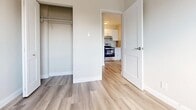 Located at 311 Central Ave in London, Ontario, this efficiently designed one-bedroom unit offers a clean, modern aesthetic throughout its single floor. Light-toned hardwood-style flooring runs continuously across all rooms, creating a cohesive and bright atmosphere.

The open living area connects seamlessly to a well-appointed kitchen featuring white cabinetry, a subway tile backsplash, and stainless steel appliances including a range and refrigerator. The kitchen is thoughtfully laid out to maximize functionality within the available space.

A standout feature of the living area is a full-height sliding glass door that opens to a private balcony, offering elevated views of the surrounding London cityscape and flooding the interior with natural light. The neutral grey-toned walls complement the light flooring and contribute to an airy, modern feel throughout.

The bedroom is a cozy, well-proportioned room with a standard window that frames views of the neighbourhood. A baseboard heater ensures year-round comfort. The bedroom also includes a dedicated closet with built-in shelving, providing practical storage. A separate white interior door leads back to the main living and kitchen area, maintaining a clear and functional layout.

Overall, this unit presents a clean, move-in-ready space with contemporary finishes suited for efficient urban living.