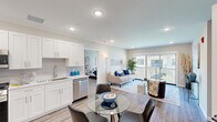 This well-appointed 2-bedroom, 2-bathroom residence at 266 Morris Ave in Long Branch, NJ offers a thoughtfully designed single-floor layout with a bright, open feel throughout. The open-concept kitchen and living area serves as the heart of the home, where white shaker cabinetry, a classic subway tile backsplash, light quartz countertops, and a full suite of stainless steel appliances — including a gas range, built-in microwave, dishwasher, and French door refrigerator — create a sleek, functional space. Recessed lighting and light-toned hardwood-style flooring run throughout, enhancing the airy atmosphere. The living room flows naturally from the kitchen and dining area, leading to a sliding glass door that opens to a private balcony with outdoor views. The spacious primary bedroom includes access to a walk-in closet and a dedicated en-suite bathroom featuring a large walk-in shower with floor-to-ceiling marble-style tile and a rainfall showerhead. The second bathroom offers a full tub-shower combination with matching marble-style tile surround and brushed nickel fixtures. The second bedroom includes a built-in closet and generous natural light. A utility room, hallway, and additional closet storage complete the practical layout of this modern Long Branch residence.
