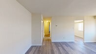 Located at 1260 Rossiter Ave in Baltimore, Maryland, this single-floor residence offers a practical and well-organized layout with two bedrooms, one bathroom, a living room, and a kitchen. The interior is finished with consistent wood-look laminate flooring throughout, lending a clean and cohesive aesthetic to every room.

The living room is the largest area of the home, featuring neutral cream-toned walls, a wide window with slatted blinds that allows ample natural light, and an open connection to adjacent spaces. A wall-mounted thermostat highlights the room's functional design.

The spacious primary bedroom offers generous floor space, a closet with built-in shelving rods, and a window for natural light. The second bedroom also features a window and closet access, maintaining a consistent, comfortable feel.

The galley-style kitchen is efficiently designed, featuring warm honey-toned wood cabinetry, light laminate countertops, a white gas range with overhead exhaust, a refrigerator, and a built-in microwave — all under a flush ceiling light fixture.

The bathroom includes a full tub and shower combination with white subway tile surround, chrome fixtures, and tile flooring, offering a clean and functional finish.

Overall, the home presents a bright, neutral palette with practical finishes throughout.