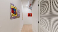 Located at 1818 N 53rd St in Philadelphia, PA, this thoughtfully designed 2-bedroom, 2-bathroom residence offers a modern aesthetic with high-end finishes throughout. The open-concept living and kitchen area is anchored by soaring ceilings with exposed industrial ductwork, lending a loft-like character to the space. Large windows flood the living room with natural light and offer neighborhood views, while light-toned hardwood floors run seamlessly throughout.

The kitchen is a standout feature, boasting quartz waterfall countertops, two-tone cabinetry with warm walnut lower cabinets and light upper cabinets, a bold geometric tile backsplash, stainless steel appliances, and stylish globe pendant lighting. The primary bedroom is generously sized, featuring a large picture window with garden views and ample closet space. The second bedroom is bright and airy, with dual oversized windows that invite abundant natural light and neighborhood views.

Both bathrooms are elegantly appointed — one showcasing a gray shaker vanity with white countertop and a tub/shower combination enclosed in sleek black-framed glass with textured tile surround, set against marble-look flooring. A dedicated closet adds practical storage. The overall ambiance is clean, contemporary, and bright, creating a welcoming and functional living environment.