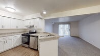 Located at 4667 Fox Valley Dr in Portage, Michigan, this single-floor unit offers a well-designed, open layout that balances functionality and comfort. The kitchen is a standout feature, boasting crisp white shaker-style cabinetry extending to the ceiling, light granite-style countertops, wood-look flooring, and a full suite of stainless steel appliances including a gas range, dishwasher, and refrigerator. A peninsula counter connects the kitchen to the living area, creating a seamless open-concept flow ideal for everyday living and entertaining. The living room is generously sized, finished with neutral carpet, and filled with natural light from a sliding glass door fitted with vertical blinds that provides direct access to the outdoors. A dedicated bedroom offers a quiet, carpeted retreat with a large window framing views of surrounding greenery, keeping the space bright and airy. The bathroom features wood-look flooring, a vanity with matching granite-style countertops, and clean, neutral finishes throughout. The entryway, visible from the living area, includes a closet with louvered doors for convenient storage. Overall, the unit presents a clean, modern aesthetic with consistent finishes and a practical, comfortable floor plan.