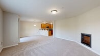 Located in Kirkland, WA, this well-appointed 3-bedroom, 2-bathroom residence offers a thoughtfully designed single-level layout. The open-concept living, dining, and kitchen area forms the heart of the home, centered around a cozy fireplace and large windows that fill the space with natural light and tree-lined views. The kitchen is well-equipped with warm honey-toned cabinetry, dark countertops, stainless steel appliances including a range, microwave, and refrigerator, and a breakfast bar that opens to the living area — ideal for both cooking and casual dining. Plush wall-to-wall carpeting runs throughout the living spaces and bedrooms, lending a warm and comfortable feel. The generously sized primary bedroom enjoys abundant natural light through wide windows and direct access to a private bathroom. Two additional bedrooms offer versatility for guests, a home office, or family use, each with ample closet space. The bathrooms are finished with tile flooring and include a tub-shower combination. A hallway connects the private quarters to the main living spaces, and a balcony provides a pleasant outdoor retreat. With five closets throughout, storage is plentiful in this inviting Kirkland residence.