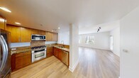 This thoughtfully designed 2-bedroom, 2-bathroom residence offers a comfortable and functional single-floor layout. The open-concept kitchen flows seamlessly into the living area, featuring warm wood cabinetry, granite countertops, a tile backsplash, and a full suite of stainless steel appliances including a gas range, built-in microwave, and dishwasher. Light hardwood-style flooring unifies the kitchen and living spaces, while large windows with blinds invite generous natural light throughout.

The spacious living room provides an airy, open feel with track lighting overhead and direct access to an exterior door, adding convenience and additional light. Both bedrooms are finished with plush carpet and feature windows with outdoor views, creating bright and restful retreats. Each bedroom includes its own closet, with one offering a walk-in closet with wire shelving for organized storage.

The primary bathroom is well-appointed with dual granite-topped vanities, a large mirror, a soaking tub, and a separate glass-enclosed shower. The second bathroom features a classic tiled tub-shower combination. Clean white walls and recessed lighting throughout lend the entire residence a bright, modern ambiance.