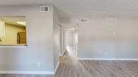 Located at 1175 Pinellas Point Dr S in Saint Petersburg, FL, this single-floor, 2-bedroom, 2-bathroom residence offers a clean, functional layout finished with neutral warm-gray tones throughout. Light wood-look flooring runs continuously across the living spaces, complemented by crisp white baseboards and textured walls that give the interior a fresh, well-maintained feel.

The combined living and dining area provides an open, versatile space anchored by a sliding glass door that welcomes natural light and provides outdoor access. A separate entry door with a window further brightens the room. The galley-style kitchen is well-appointed with white shaker cabinetry, light countertops, a stainless steel sink, dishwasher, refrigerator, range, and over-the-range microwave, along with an adjacent pantry for additional storage.

The primary bedroom is generously proportioned and features dual closets and a window overlooking the outdoors. The second bedroom also includes a closet and maintains the same light, neutral aesthetic. A central hallway connects the bedrooms to two full bathrooms, each finished with light countertops, white vanity cabinetry, and wood-look flooring. Four closets total are distributed throughout the home, providing ample storage. The textured ceilings add a subtle architectural detail consistent across all rooms.