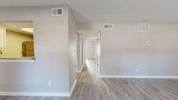 Located at 1175 Pinellas Point Dr S in Saint Petersburg, FL, this single-floor, 2-bedroom, 2-bathroom residence offers a clean, functional layout finished with neutral warm-gray tones throughout. Light wood-look flooring runs continuously across the living spaces, complemented by crisp white baseboards and textured walls that give the interior a fresh, well-maintained feel.

The combined living and dining area provides an open, versatile space anchored by a sliding glass door that welcomes natural light and provides outdoor access. A separate entry door with a window further brightens the room. The galley-style kitchen is well-appointed with white shaker cabinetry, light countertops, a stainless steel sink, dishwasher, refrigerator, range, and over-the-range microwave, along with an adjacent pantry for additional storage.

The primary bedroom is generously proportioned and features dual closets and a window overlooking the outdoors. The second bedroom also includes a closet and maintains the same light, neutral aesthetic. A central hallway connects the bedrooms to two full bathrooms, each finished with light countertops, white vanity cabinetry, and wood-look flooring. Four closets total are distributed throughout the home, providing ample storage. The textured ceilings add a subtle architectural detail consistent across all rooms.