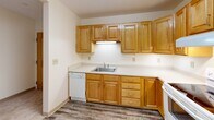 Located at 44 School St in Weston, MA, this two-bedroom, one-bathroom residence offers a practical and comfortable single-floor layout. The space features a well-appointed kitchen equipped with warm honey-toned wood cabinetry, ample upper and lower storage, light countertops, and white appliances including a dishwasher, electric range, and a full-size refrigerator. Durable wood-look flooring runs throughout the kitchen, adding a clean, neutral aesthetic.

Both bedrooms are carpeted and finished in soft, neutral tones, creating a calm and inviting atmosphere. The generously sized primary bedroom features multiple windows that invite natural light and offer pleasant views of the surrounding greenery, providing a bright and airy feel. The second bedroom is similarly carpeted and offers a comfortable, quiet retreat.

The bathroom is designed with accessibility in mind, featuring stainless steel grab bars near the toilet and along the shower area, white tile flooring, and a clean, open layout. A hallway connects the living areas, providing a logical and efficient flow throughout the residence. The entrance leads conveniently into the main living space. Overall, the unit presents a straightforward, functional design well-suited for comfortable everyday living in the charming town of Weston, Massachusetts.