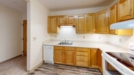 Located at 44 School St in Weston, MA, this two-bedroom, one-bathroom residence offers a practical and comfortable single-floor layout. The space features a well-appointed kitchen equipped with warm honey-toned wood cabinetry, ample upper and lower storage, light countertops, and white appliances including a dishwasher, electric range, and a full-size refrigerator. Durable wood-look flooring runs throughout the kitchen, adding a clean, neutral aesthetic.

Both bedrooms are carpeted and finished in soft, neutral tones, creating a calm and inviting atmosphere. The generously sized primary bedroom features multiple windows that invite natural light and offer pleasant views of the surrounding greenery, providing a bright and airy feel. The second bedroom is similarly carpeted and offers a comfortable, quiet retreat.

The bathroom is designed with accessibility in mind, featuring stainless steel grab bars near the toilet and along the shower area, white tile flooring, and a clean, open layout. A hallway connects the living areas, providing a logical and efficient flow throughout the residence. The entrance leads conveniently into the main living space. Overall, the unit presents a straightforward, functional design well-suited for comfortable everyday living in the charming town of Weston, Massachusetts.