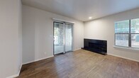 Located at 4434 E 66th St S in Tulsa, Oklahoma, this well-appointed two-bedroom, two-bathroom unit offers a thoughtfully designed single-level layout. The living room serves as a central gathering space, highlighted by a sleek black-tiled fireplace, wood-look hardwood flooring, and a sliding glass door that opens to an outdoor area with a striking stone exterior backdrop, filling the room with natural light. The galley-style kitchen is efficiently arranged with white cabinetry, white quartz countertops, a classic subway tile backsplash, stainless steel appliances including a dishwasher and range, and a modern pull-down faucet at the undermount sink. Wood-look flooring continues through the kitchen and into the hallway, which connects seamlessly to the rest of the unit via a dedicated entrance. Both bedrooms are comfortably sized, featuring plush carpeting, ceiling fans with light fixtures, and closets with built-in shelving for organized storage. The primary bedroom includes sliding door access to an outdoor area. Both bathrooms are clean and functional, each offering a tiled tub-shower combination with white fixtures and wood-look flooring. A hallway and entrance area complete the practical, well-connected layout of this Tulsa residence.