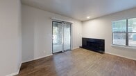 Located at 4434 E 66th St S in Tulsa, Oklahoma, this well-appointed two-bedroom, two-bathroom unit offers a thoughtfully designed single-level layout. The living room serves as a central gathering space, highlighted by a sleek black-tiled fireplace, wood-look hardwood flooring, and a sliding glass door that opens to an outdoor area with a striking stone exterior backdrop, filling the room with natural light. The galley-style kitchen is efficiently arranged with white cabinetry, white quartz countertops, a classic subway tile backsplash, stainless steel appliances including a dishwasher and range, and a modern pull-down faucet at the undermount sink. Wood-look flooring continues through the kitchen and into the hallway, which connects seamlessly to the rest of the unit via a dedicated entrance. Both bedrooms are comfortably sized, featuring plush carpeting, ceiling fans with light fixtures, and closets with built-in shelving for organized storage. The primary bedroom includes sliding door access to an outdoor area. Both bathrooms are clean and functional, each offering a tiled tub-shower combination with white fixtures and wood-look flooring. A hallway and entrance area complete the practical, well-connected layout of this Tulsa residence.