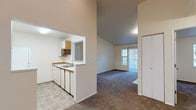 This single-floor residence offers a thoughtfully designed layout that balances open living with functional private spaces. The living room serves as the centerpiece of the home, boasting impressive vaulted ceilings that create a sense of spaciousness and height. A tile-surround fireplace with a white mantel anchors one wall, adding warmth and character to the room. Plush carpeting extends throughout the living and bedroom areas, while a sliding glass door and adjacent window flood the space with natural light and provide access to the outdoors.

The kitchen is efficiently arranged in a galley configuration, featuring tile countertops with wood-trim accents, white cabinetry, and an electric range. A pass-through window opens directly into the living area, enhancing the open-concept feel and making the kitchen ideal for entertaining. Tile flooring in the kitchen provides a practical and easy-to-maintain surface.

The bedroom is a comfortable, carpeted retreat with a large window overlooking the outdoors and a baseboard heater for year-round comfort. A closet offers convenient storage within the unit.

The bathroom is clean and classic, featuring a full soaking tub and shower combination enclosed by white subway-style tile that extends floor to ceiling, complemented by chrome fixtures for a timeless look throughout.