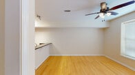 Located at 27 Renewal Street in Pendleton, South Carolina, this three-story home offers a well-organized layout across multiple levels. The main living area features warm hardwood-style flooring that flows through the open layout, connecting a spacious living area to the kitchen. The kitchen is well-appointed with rich granite countertops, warm wood cabinetry, stainless steel appliances including a refrigerator and range, and a double undermount sink—making it a functional and attractive space for everyday use.

The main level also includes a hallway with closet storage and convenient access to additional rooms. A half bath on this level features a single vanity and tile flooring, with a washer visible nearby, suggesting laundry access on the main floor.

Upper levels host multiple carpeted bedrooms, each equipped with ceiling fans and windows that bring in natural light. One bedroom stands out with vaulted ceilings that add architectural interest and a sense of spaciousness. The bathrooms feature tile flooring, wood vanities with white countertops, and tub-shower combinations with brushed nickel fixtures. The overall palette of neutral tones throughout creates a clean, cohesive ambiance suited to a variety of décor styles.